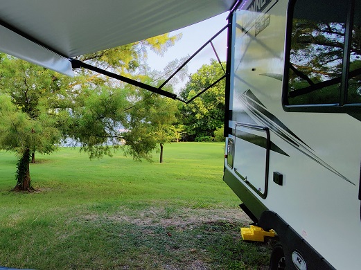looking at the campground from under the awning reading about RV maintenance tips